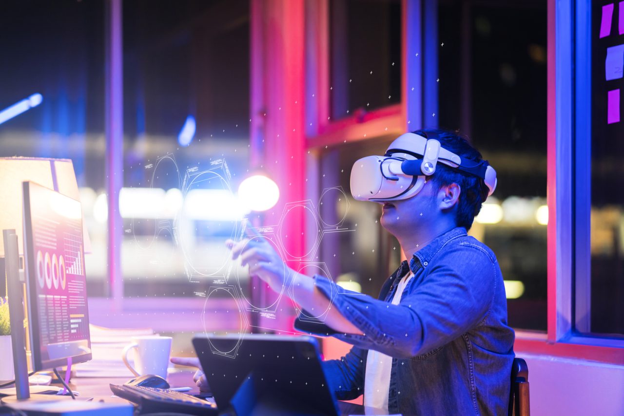 asian-young-male-wearing-wearable-goggle-headset-virtual-online-meeting-digital-space-working-with-3d-augmented-dimension-homecyber-virtual-working-with-virtual-vr-goggle-pc-desktop-device-2-3-1280x854.jpg